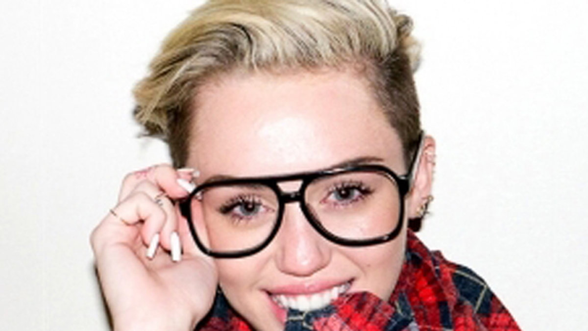 Miley poserar med Terrys skjorta och glasögon. 