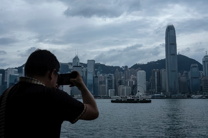 En man fotograferar Hongkongs skyline inför tyfonen Ragasas ankomst på tisdagen.
