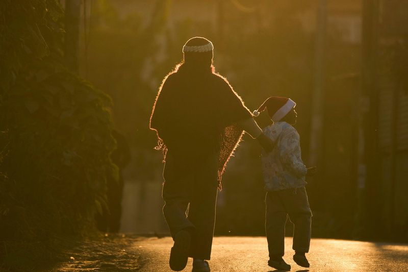 En pojke i tomtemössa på promenad tillsammans med sin mor i Lalitpur i Nepal. 