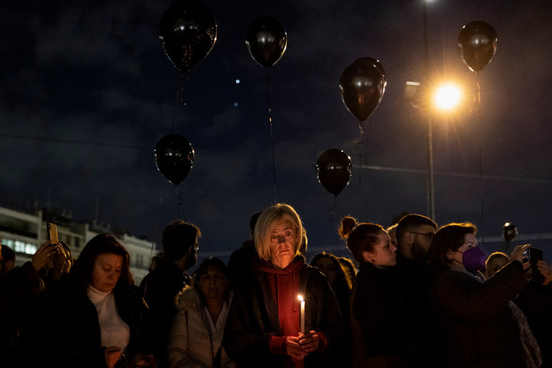 Demonstranter håller en tyst minut framför parlamentet i Aten under fredagskvällen. Tusentals protesterade i huvudstaden.