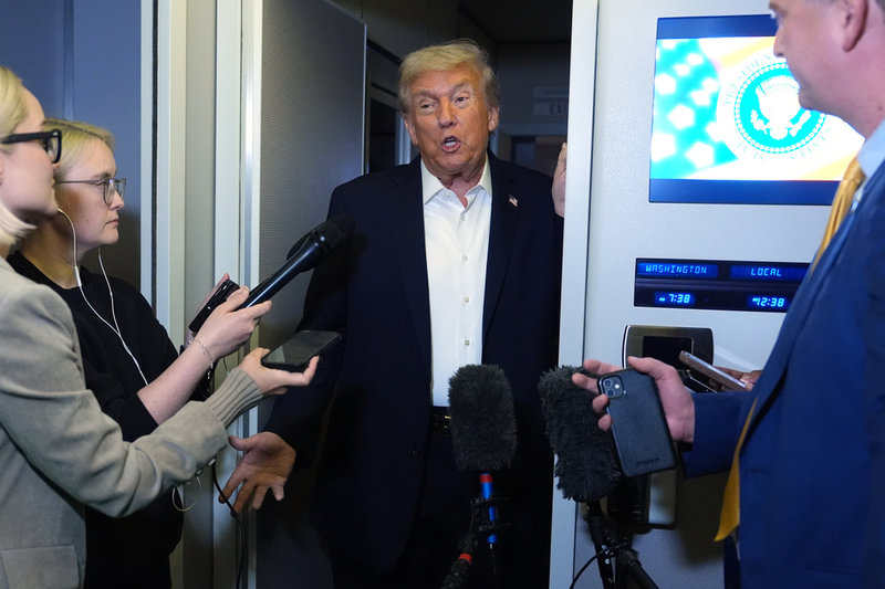 Donald Trump talar med reportrar ombord på presidentplanet Air Force One på tisdagen.