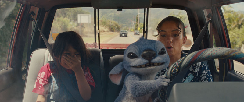 Stitch omgiven av Lilo (Maia Kealoha) och Nani (Sydney Agudong) i 'Lilo & Stitch'. Pressbild.