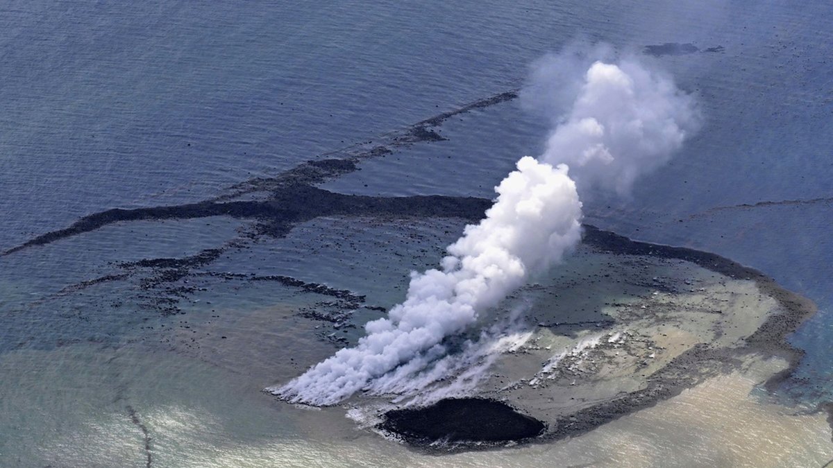 Ånga bolmar ur vattnet där ett vulkanutbrott har skapat en ny ö.
