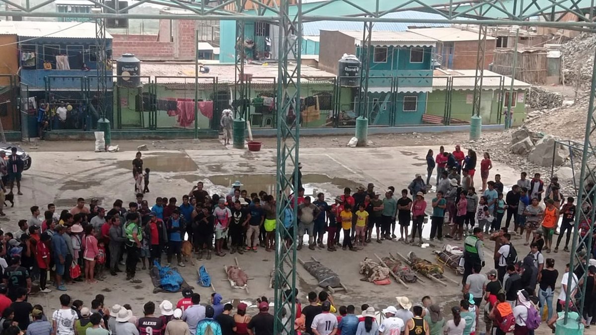Människor samlas kring bärgade avlidna i staden Camaná.