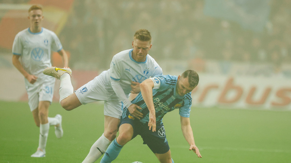 Malmö FF:s vitklädde Anders Christiansen i duell med Piotr Johansson.