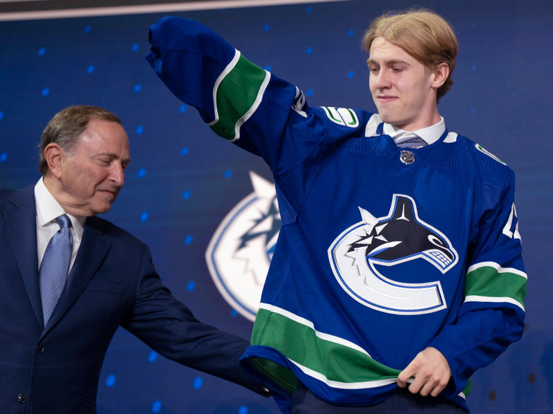 NHL-kommissionären Gary Bettman hjälper Jonathan Lekkerimäki med Vancouver-tröjan under NHL-draften i juli. Arkivbild.