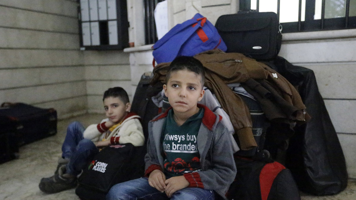 Två syriska pojkar väntar på ett flygplan som ska ta dem till Tyskland och säkerheten. Oktober 2013. 