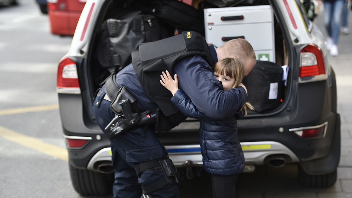 Ett barn som kramar en polis. 