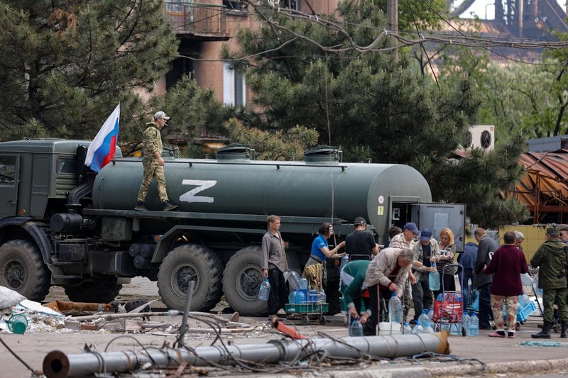 Stadsbor i Mariupol hämtar vatten som distribueras av ryska ockupationsmyndigheter. Kriget hotar folkhälsan i Ukraina på både kort och lång sikt, enligt WHO.