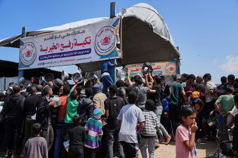 Palestinier köar för ett gratis mål mat i Khan Yunis i södra Gazaremsan på måndagen.