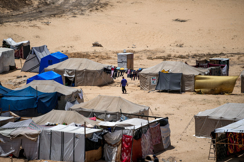 En man går genom ett provisoriskt tältläger nära Khan Yunis i södra Gaza den 4 juli.