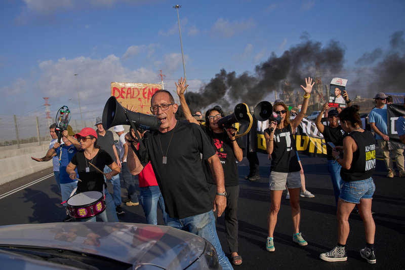 Demonstranter på en motorväg nära Lod strax utanför Tel Aviv. De kräver en vapenvila och ett avtal som får hem gisslan från Hamas fångenskap i Gazaremsan.