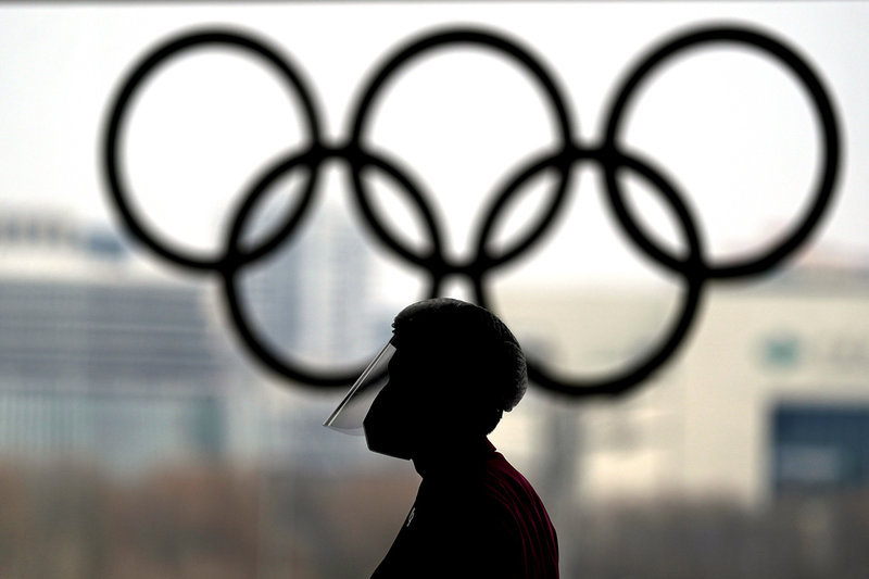 En person iförd skyddsutrustning mot coronaviruset i OS-presscentret i Peking.