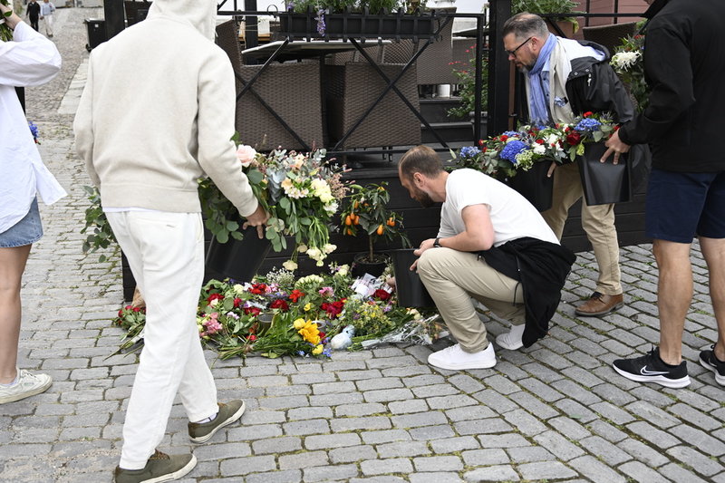 Människor lägger ned blommor på Donners plats i Visby.