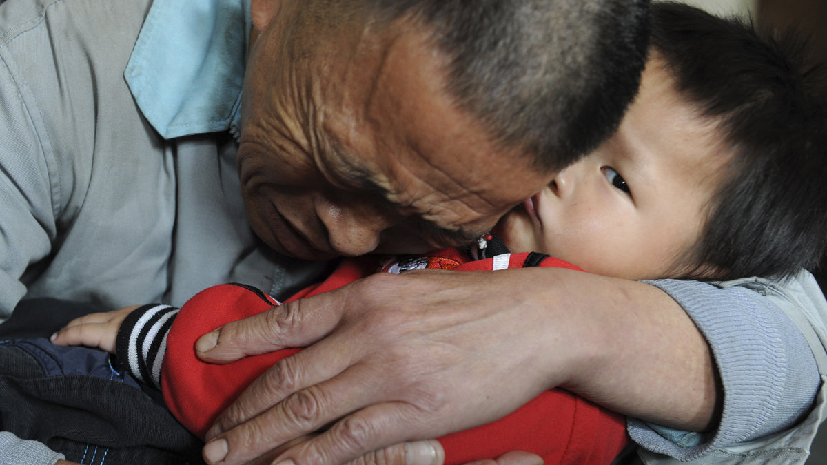 Wang Bangyin håller om sin son som kidnappades för två år sedan.