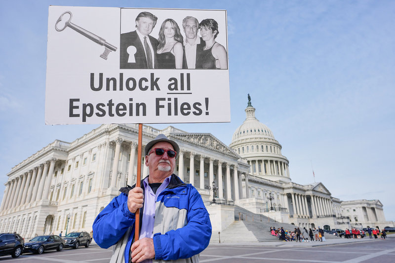 Aktivisten Gary Rush står utanför Kapitolium i Washington DC med ett plakat som visar en bild på Donald Trump, Melania Trump, Jeffrey Epstein och Ghislaine Maxwell.