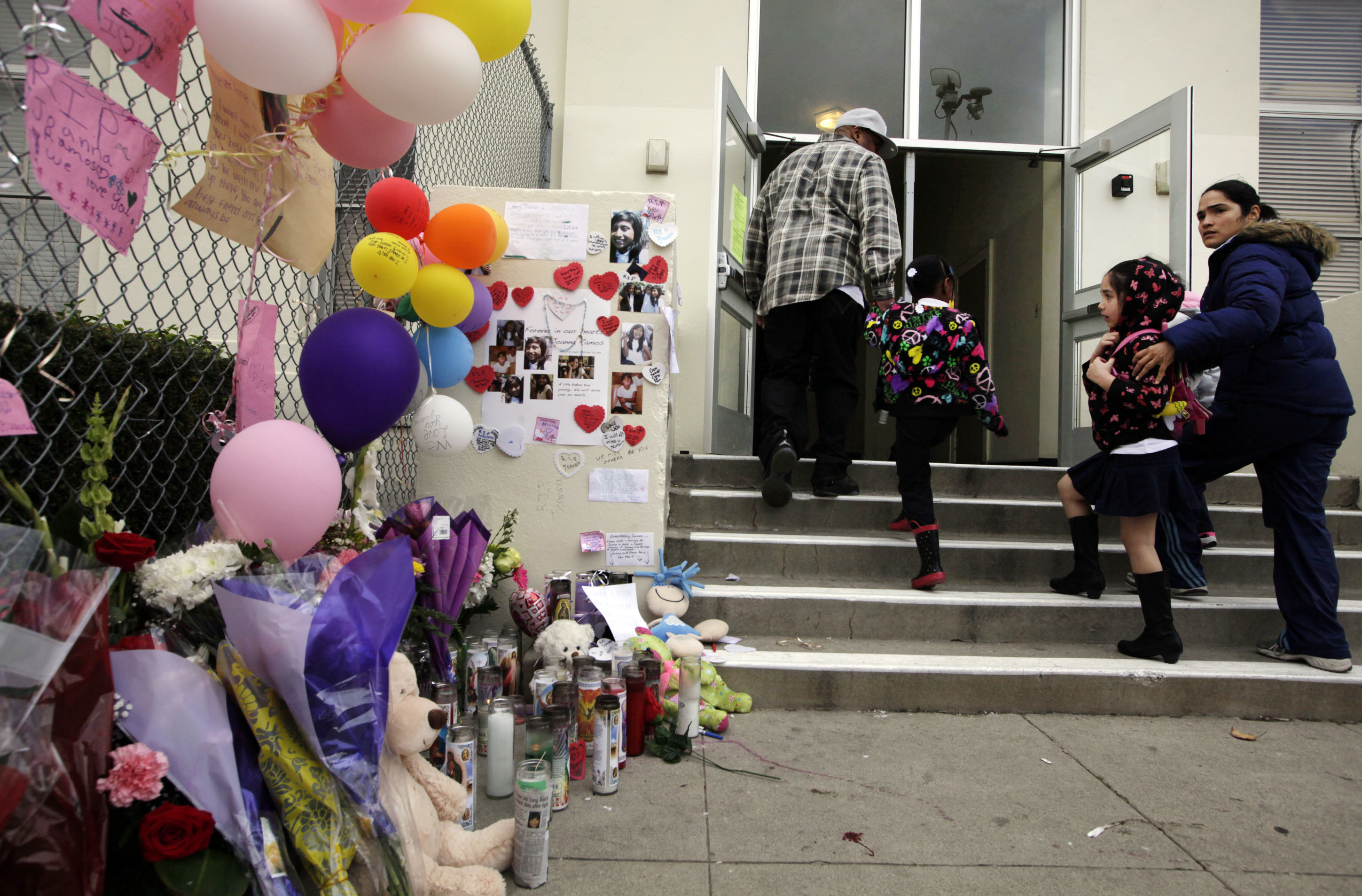 Elever och föräldrar går förbi minnesbilderna av Joanna utanför hennes skola i Long Beach, Kalifornien.