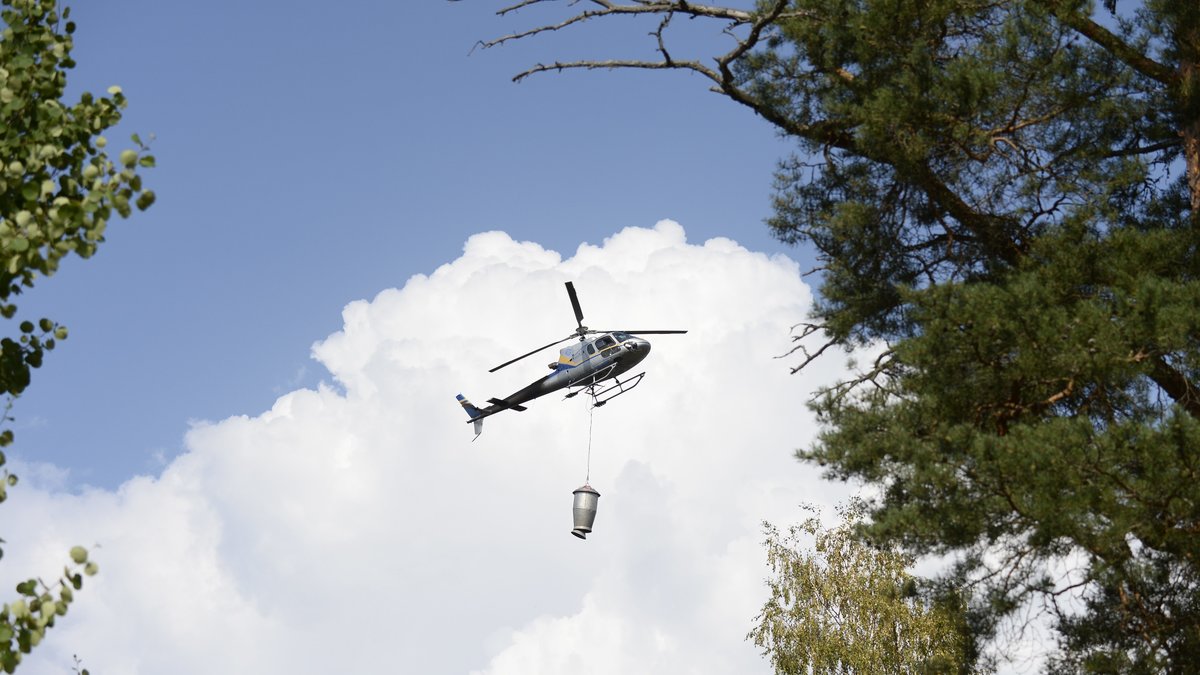 Helikoptrer som vattenbombar den stora skogsbranden, i samband med tankning i Virsbo inför nya brandbekämpande flygturer.