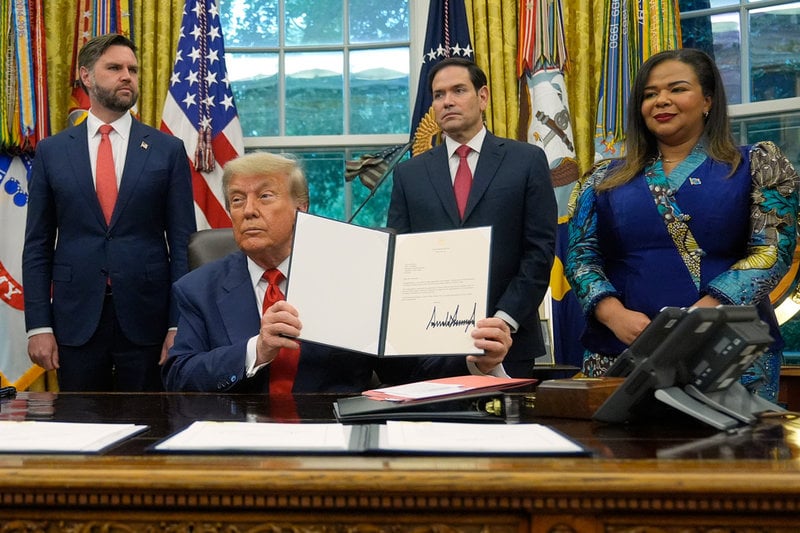USA:s president Donald Trump håller upp en överenskommelse efter "fredssamtal" mellan Rwanda och Demokratiska republiken Kongo i juni. Bakom honom syns vicepresident JD Vance, utrikesminister Marco Rubio och Kongos utrikesminister Therese Kayikwamba Wagner. Arkivbild.