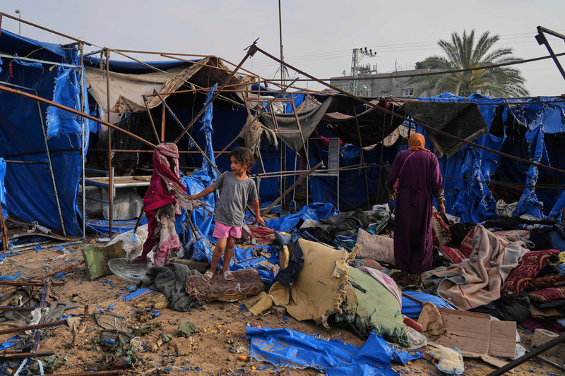 Palestinier i vad som finns kvar av deras provisoriska bostäder i Dayr al-Balah efter en israelisk attack på lördagen.