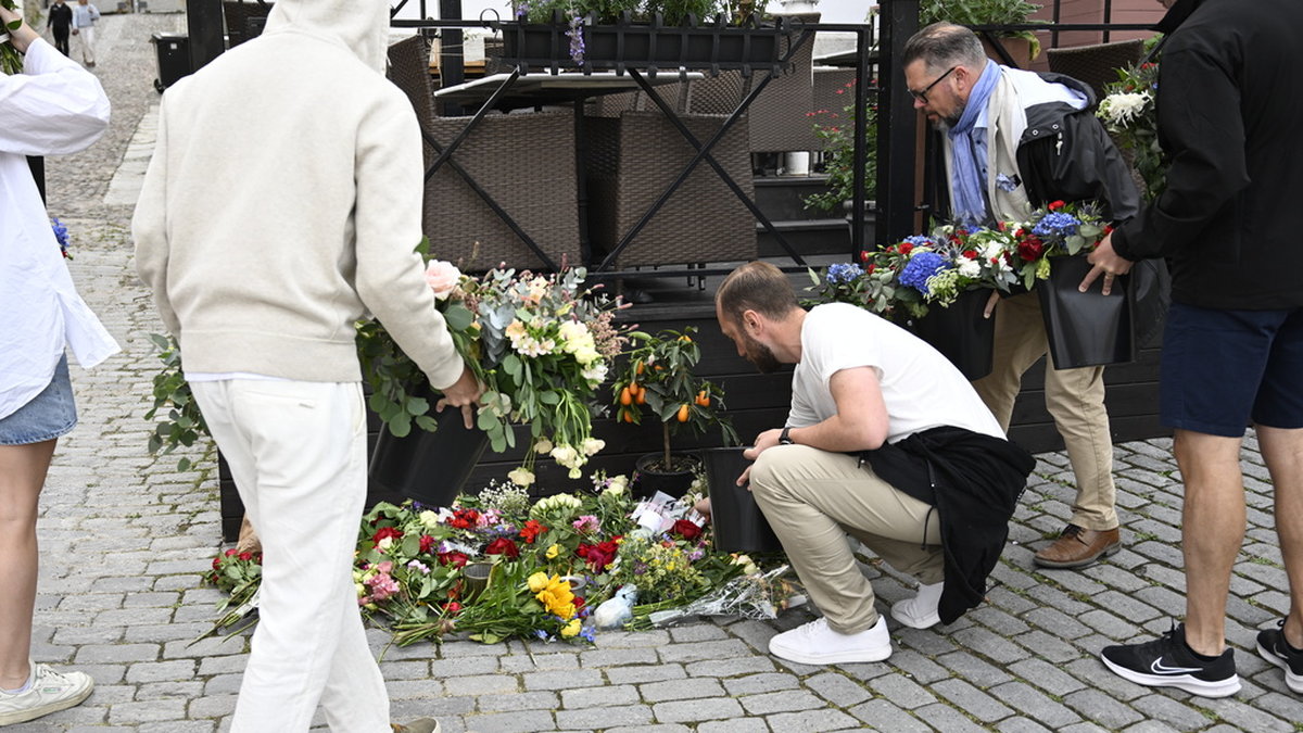 Personer lägger ned blommor vid platsen där Ing-Marie Wieselgren mördades under Almedalsveckan. Arkivbild.