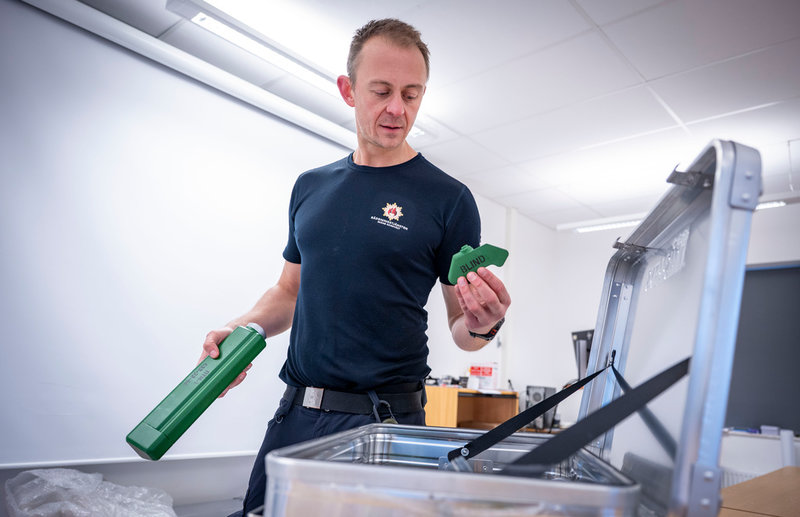 Emil Lindskog, utbildningsansvarig, visar upp 3D-printade minor och granater i plast som används vid utbildningen av brandmän.
