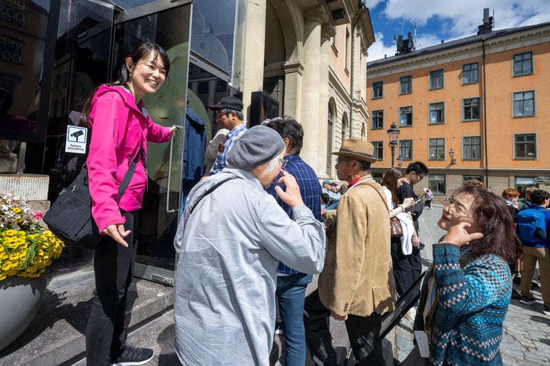 Reseledaren Fujta Miko lotsar in en turistgrupp från Japan till Nobelprismuseet i Börshuset, Stortorget, Stockholm.