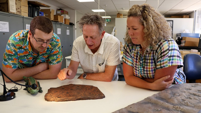 Forskarna Aaron Camens, John Long och Alice Clement vid Flinders University i Australien undersöker en kopia av stenblocket.