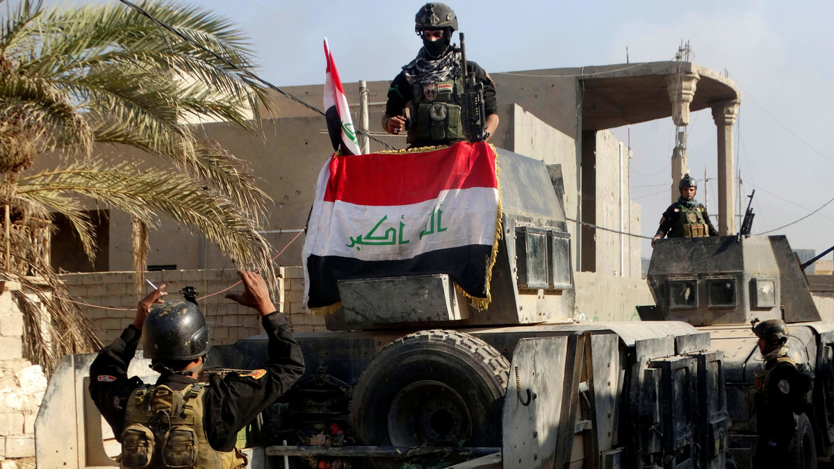 Irakiska säkerhetsstyrkor omger den statliga byggnaden. 
