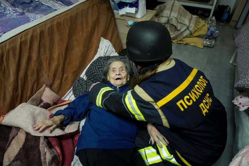 En äldre kvinna får hjälp sedan ett hospice i Kiev skadats i ryska attacker.