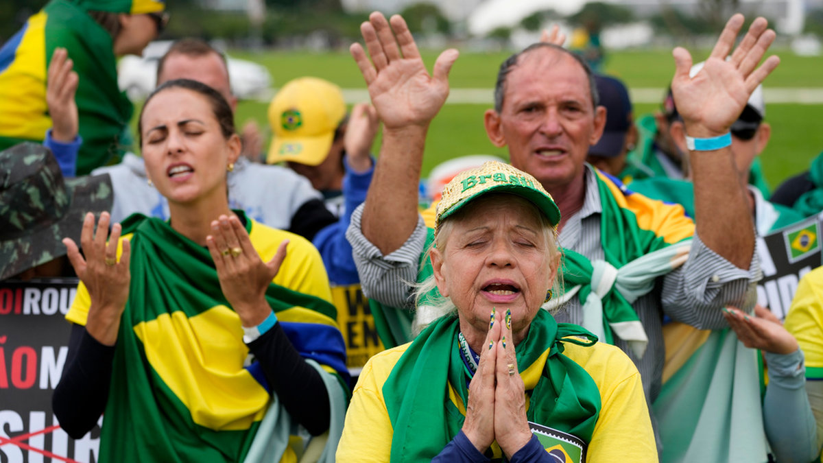 Bönestund bland Bolsonaro-anhängare under en av de demonstrationer som regelbundet hålls till stöd för honom i Brasília.