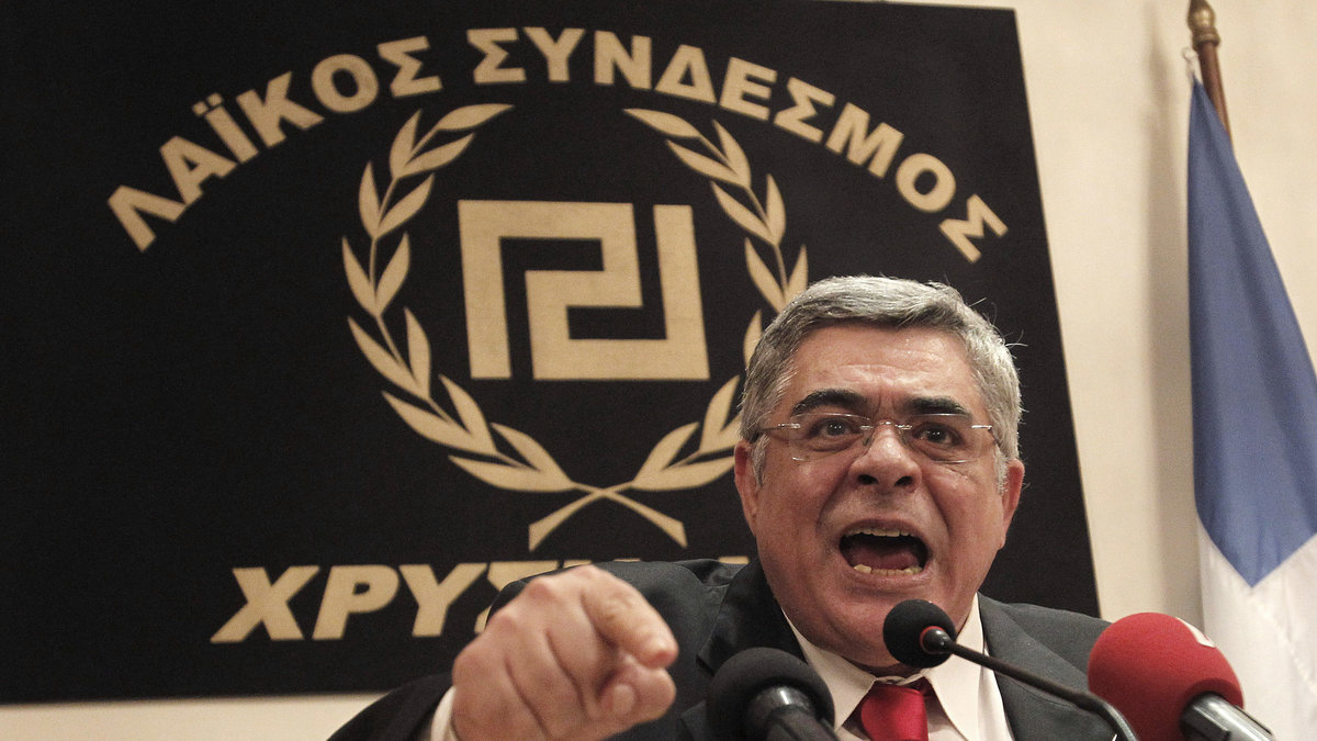 Partiets ledare Nikolaos Michaloliakos. Loggan är snarlik ett hakkors.