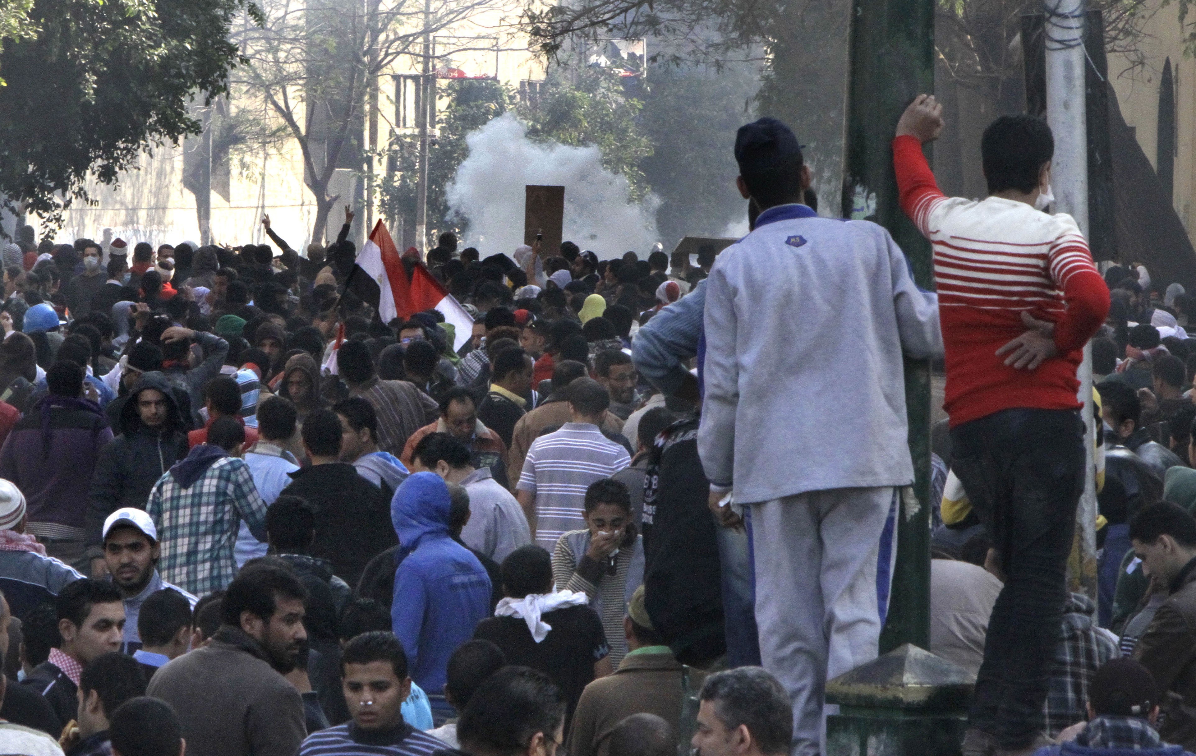 I bakgrunden en vanlig syn i Kairo dessa dagar - ett moln av tårgas.