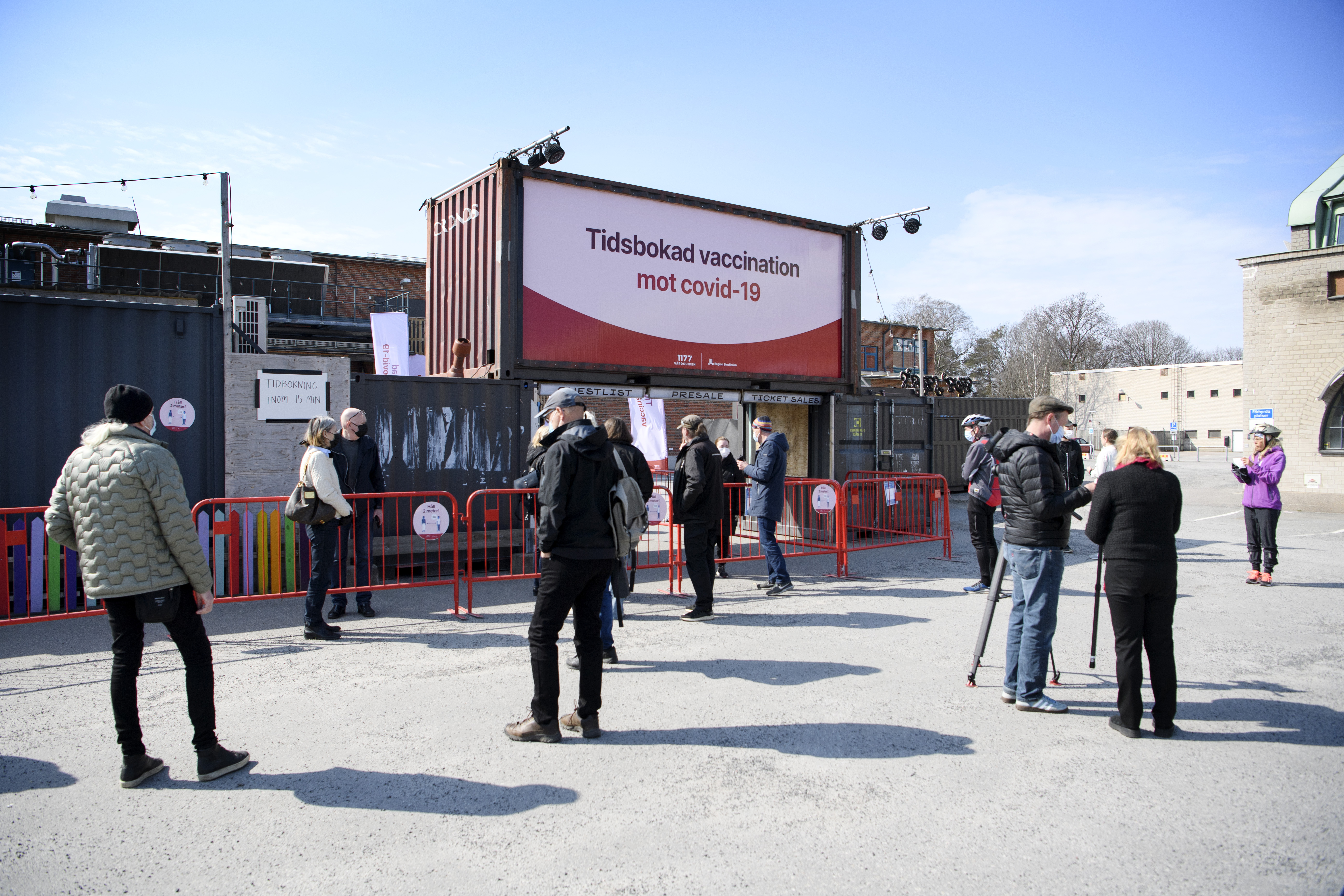 Människor väntar i kö inför vaccinering i klubblokalen Fållan i Stockholm.