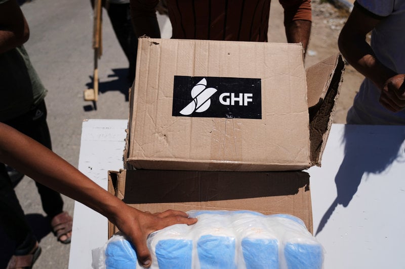 Palestinier tar för sig av mat och andra förnödenheter vid en leverans i GHF:s regi. Bild tagen i Khan Yunis-området den 29 maj.