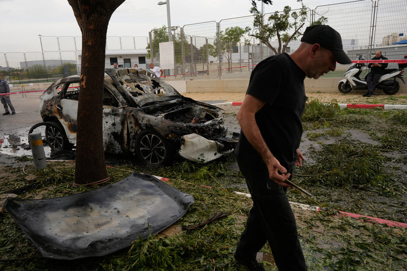 En man inspekterar platsen för en iransk robotattack i Petah Tikva, Israel, i onsdags.