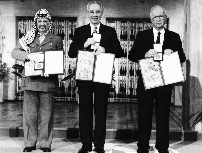 PLO-ledaren Yassir Arafat, Israels premiärminister Yitzhak Rabin och utrikesminister Shimon Peres med medaljer och diplom för Nobels fredspris 1994. Arkivbild.
