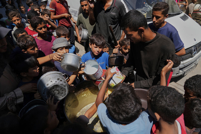 Palestinska barn köar för att få mat i Dayr al-Balah i Gaza. Bild från i fredags. 