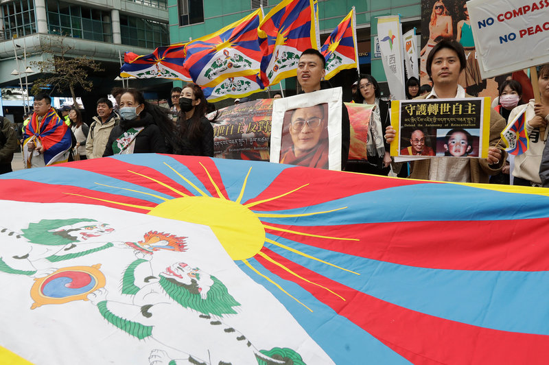 Tibetaner i Taiwan håller upp ett porträtt av Dalai lama och Tibets flagga vid en sammankomst i mars i år. 