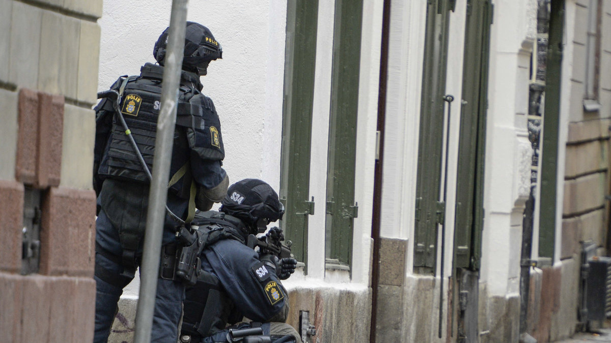 Beväpnad polis i gathörnen mot Stora Nygatan vid människorättsorganisationen Civil Rights Defenders i Gamla stan i Stockholm.