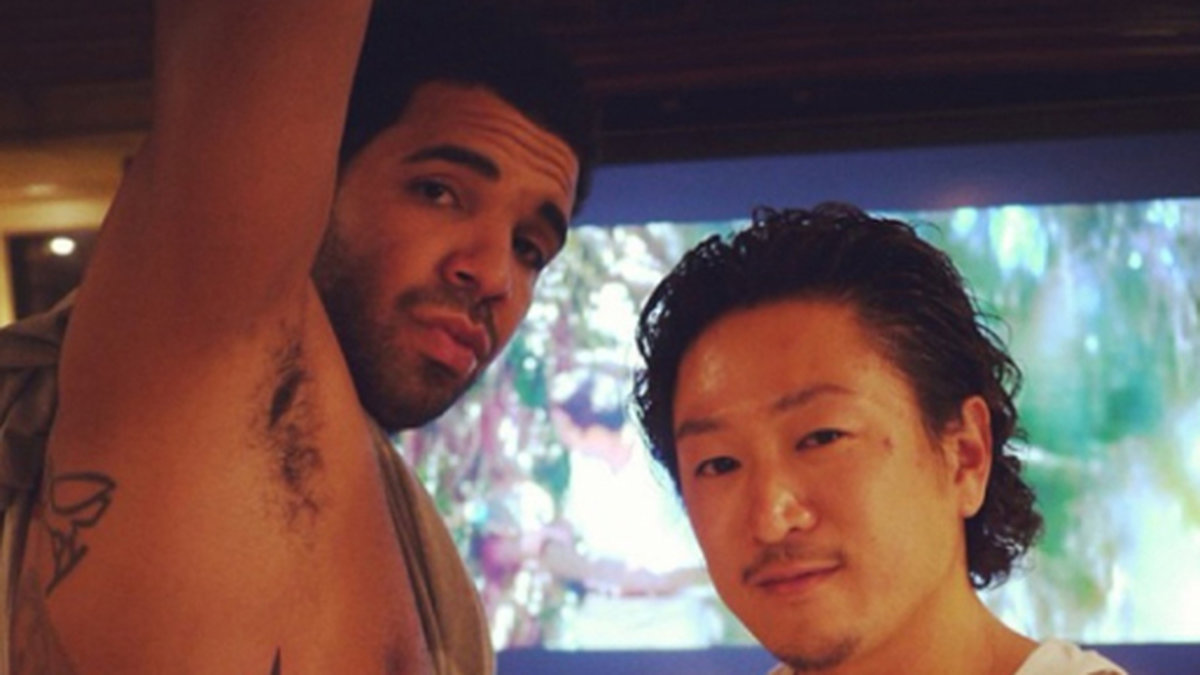 Drake visar upp några av sina tatueringar. 