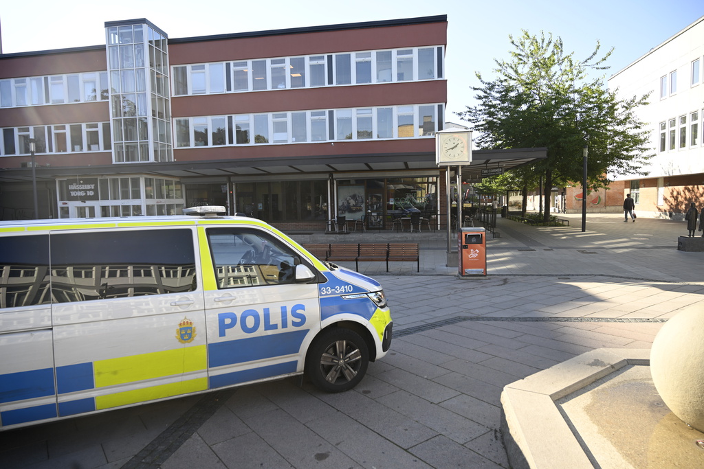 En polisbil på Hässelby torg i västra Stockholm. Polisen påträffade en skottskadad man på en krog i stadsdelen sent på söndagskvällen.