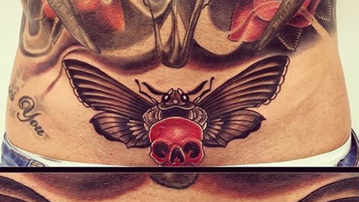Här har vi en tatuering av en dödsfjäril ovanför snoppen. 