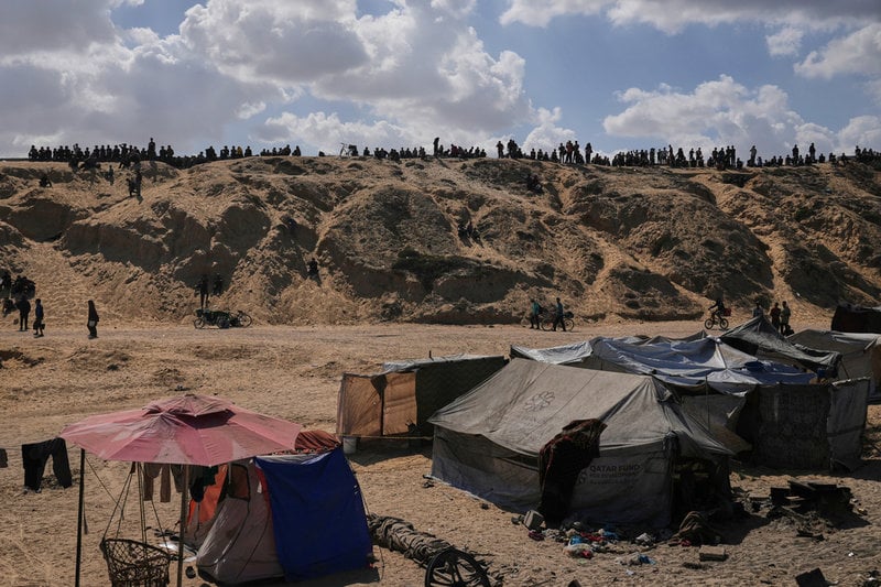 Palestinier som länge har tvingats bort från sina hem vandrar längs med en upphöjd väg i centrala Gaza. Bilden togs på fredagen.