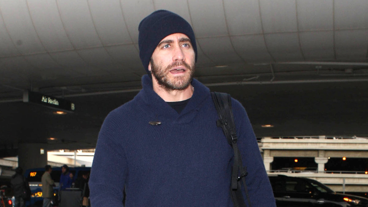 Jake Gyllenhaal med gröna byxor, blå tröja och blå mössa.