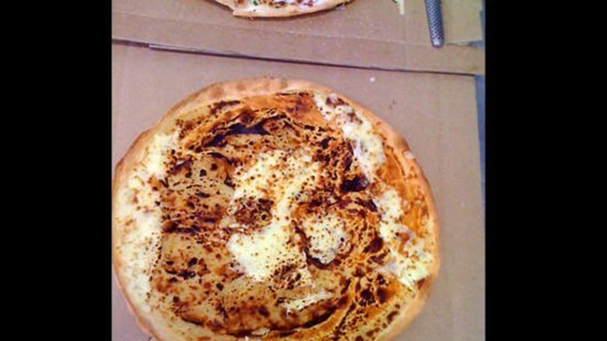 Ägarna av en pizzeria i Australien säger att Jesus ansikte visade sig i en av deras pizzor.