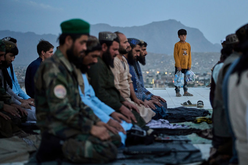 En pojke iakttar talibankrigare som samlats för bön i Kabul den 10 juni.