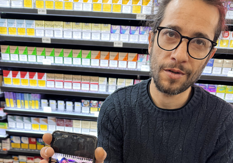  Joseph, som arbetar på en pressbyrå i Crans-Montana, visar en bild på en kvinna som saknas.