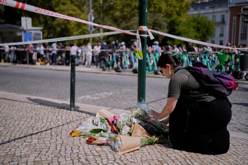 En kvinna lägger ned blommor på olycksplatsen på torsdagen.