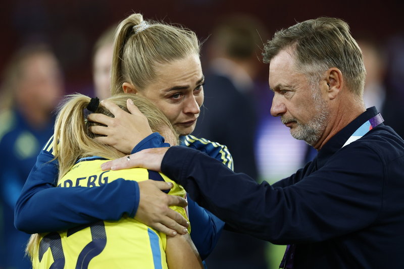 Sveriges Smilla Holmberg, som missade den sista straffen i EM-kvartsfinalen mot England, tröstas av Fridolina Rolfö och förbundskaptenen Peter Gerhardsson.